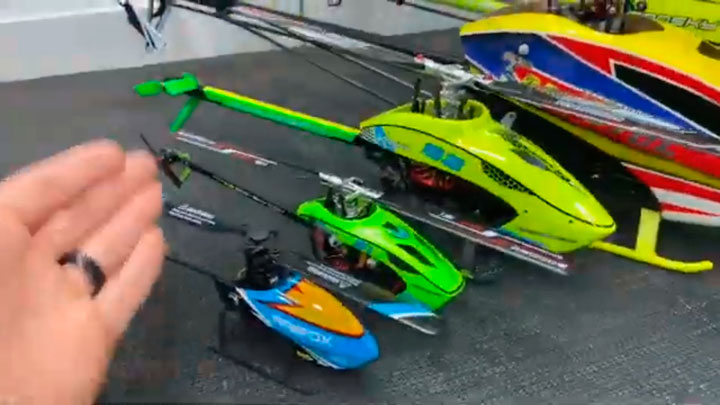 Hand points at line of model helicopters